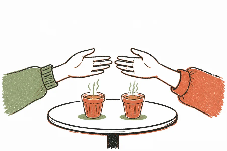 two hands reaching toward each other over a table